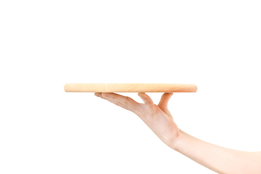 Concept of food serving service - female hand holding a wooden board on a white background in close-up