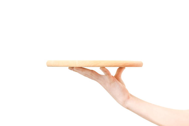 Wooden tray on a hand Concept of food serving service - female hand holding a wooden board on a white background in close-up"n tray stock pictures, royalty-free photos & images