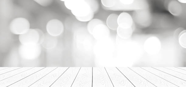 istock Empty vintage white wood table over blur store background, perspective wooden board background for product and food display montage 935435722