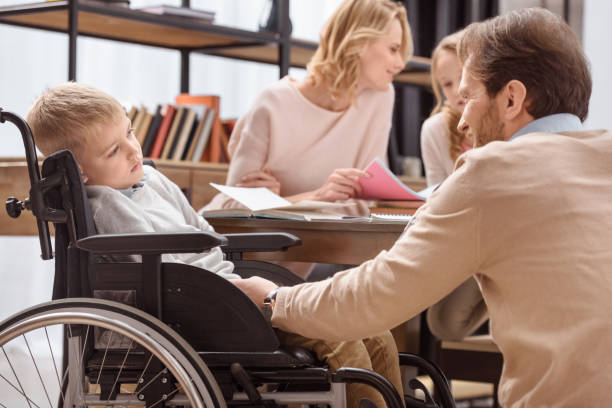 istock smiling father palming son on wheelchair 935438316
