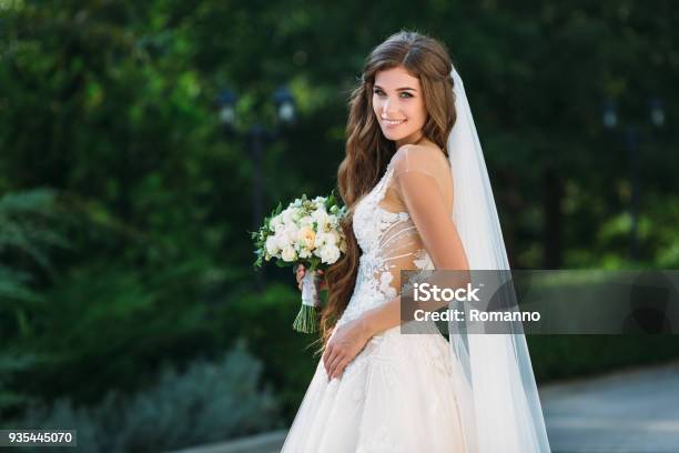 Amazing Bride In Beautiful White Wedding Dress Hold Bouquet Of Flowers In Her Hands Concept Of Clothes And Floristics Stock Photo - Download Image Now