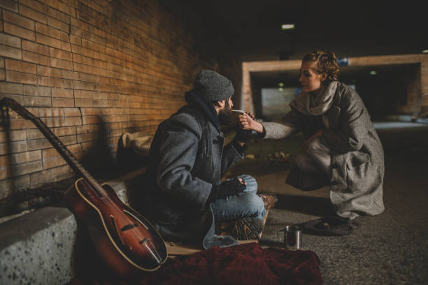 istock Woman helping the homeless man 935445092