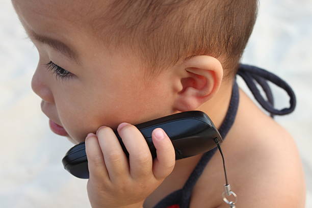 istock Asian baby,beach,sling suit,talk to a cellphone 93545501