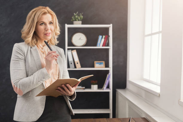 istock Businesswoman reading document at office desktop 935471380