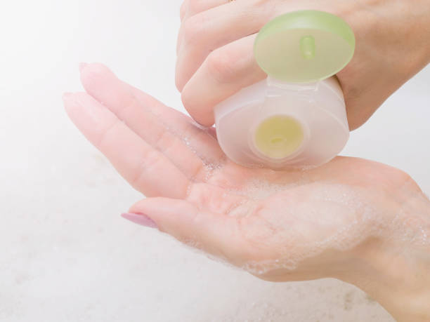istock Shampoo in hand, young woman bathing in bathroom. Cropped image, selective focus. 935472708