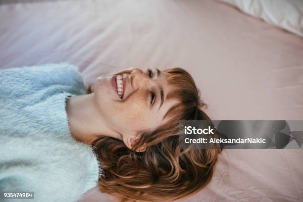 Portrait Of A Smiling Woman Lying On The Bed Stock Photo - Download Image Now - Women, Pastel Colored, Happiness