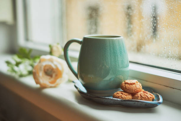 Coffee with amaretto biscuits on a window sill, during an winter day. 