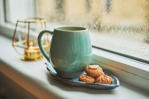 Coffee with amaretto biscuits on a window sill, during an winter day.