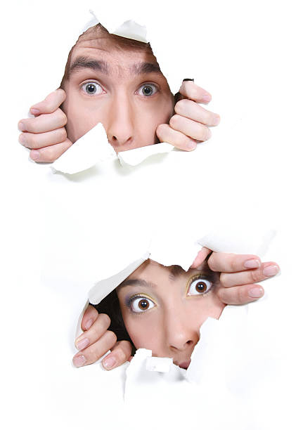 istock couple peeping through hole in white paper 93547543