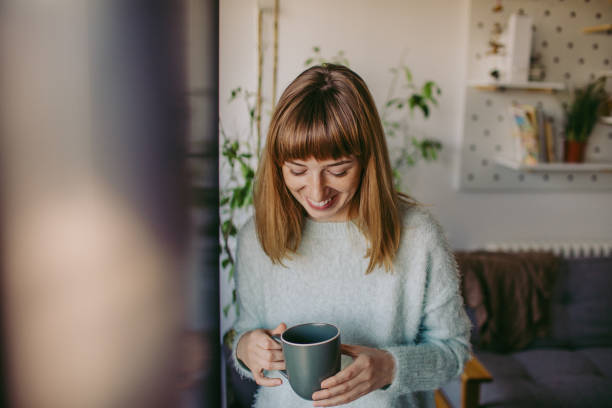 Happy, smiling woman having first morning coffee