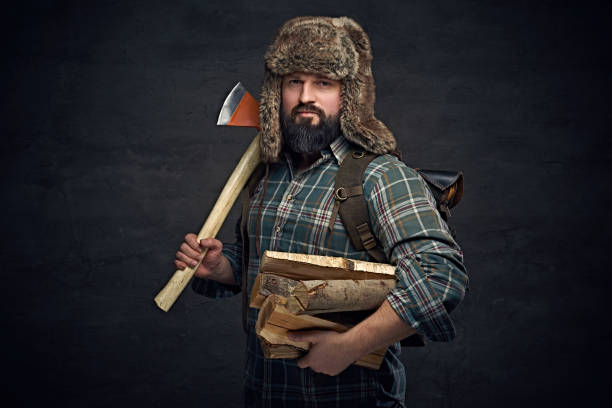 istock A man in fur hat holds an axe and firewoods. 935475698