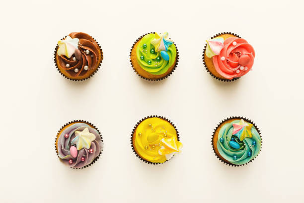 Tasty muffins with buttercream isolated on white