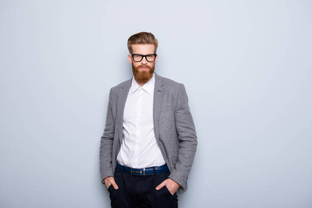 giovane bell'uomo in abbigliamento formale con barba rossa e occhiali che si tengono per mano in tasca - pocket suit glasses jacket foto e immagini stock