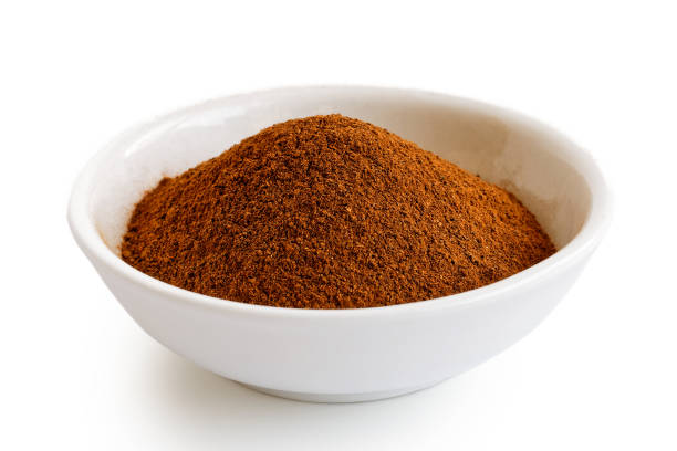 istock Finely ground cinnamon in white ceramic bowl isolated on white. 935487520
