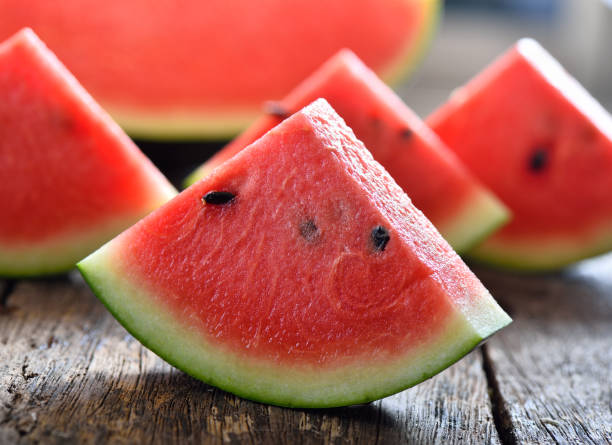 anguria affettata su sfondo legno - watermelon foto e immagini stock