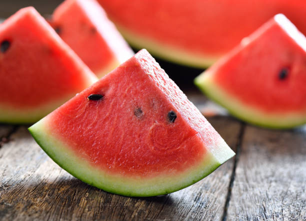istock watermelon sliced on wooden background 935496028