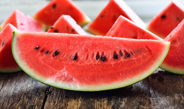 istock watermelon sliced on wooden background 935498108