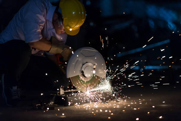 istock In selective focus and motion blur with Low light image of Worker Use Electric Angle Grinders metal  in Factory and throwing many sharp sparks. 935506778