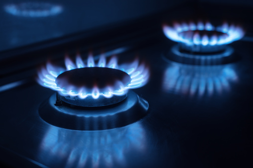 Photo of two gas burners in the darkness in the kitchen