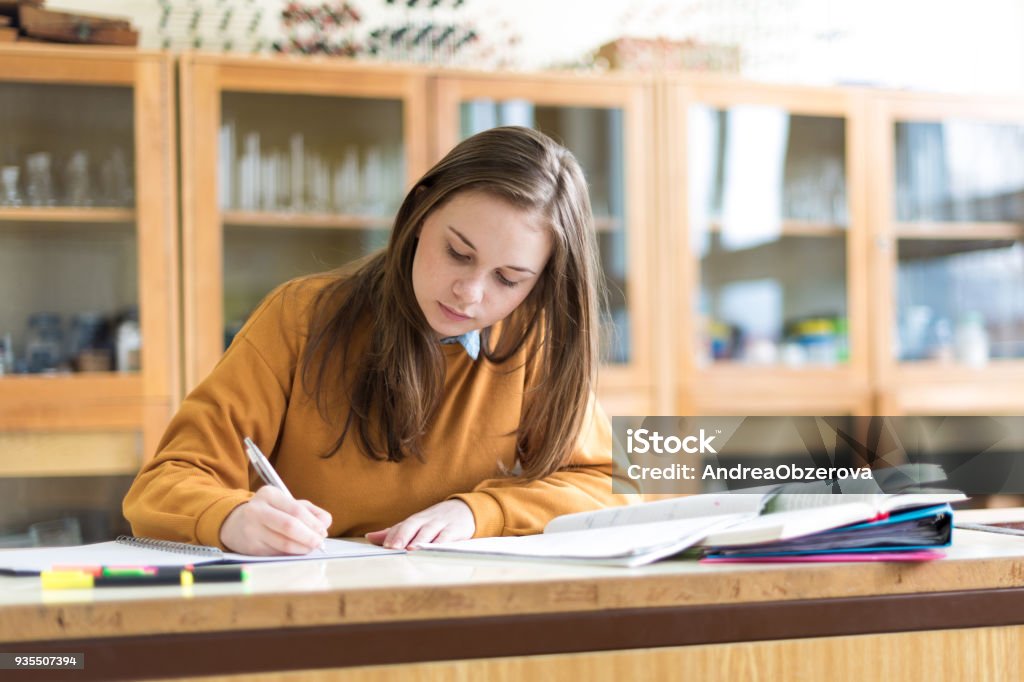 Young female college student in chemistry class, writing notes. Focused student in classroom. Authentic Education concept. Studying Stock Photo