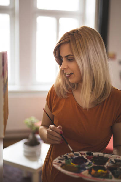 istock Creative lady painting at home 935512028