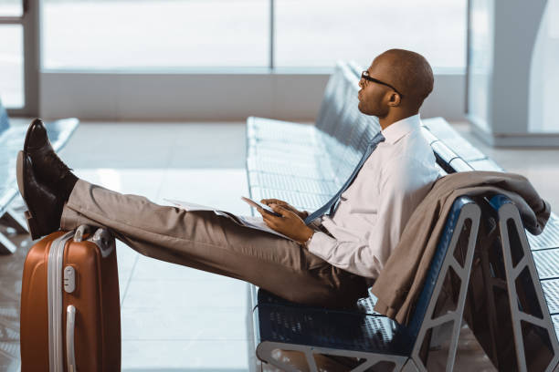 istock businessman using smartphone while waiting for flight at airport lobby 935524406