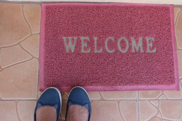 istock welcome red mat with feet ahead outside the front door 935524636