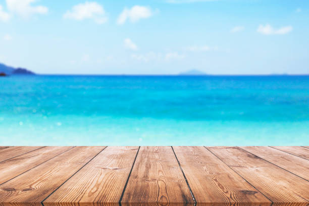 istock Wooden table with blue sea and beach background 935524654
