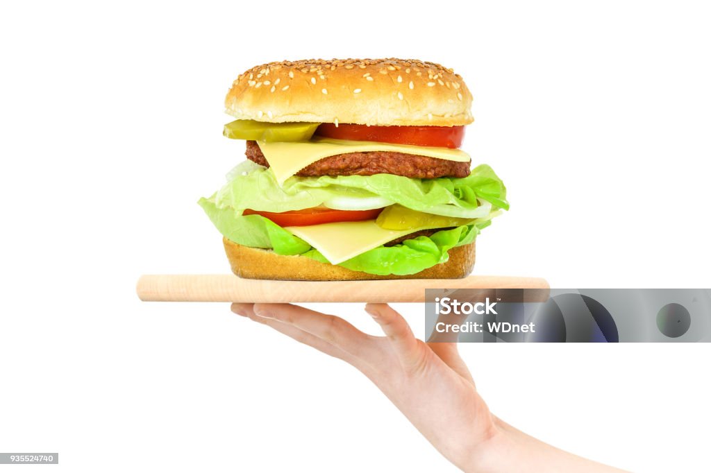 Hamburger on a wooden tray Concept of food serving service - female hand holding a wooden board with a big hamburger on a white background (mixed) Burger Stock Photo