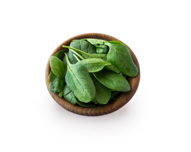 istock Spinach in wooden bowl. Top view. Spinach isolated on a white background. Green spinach with copy space for text. 935529038