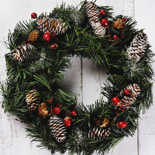 istock christmas wreath with pinecones on wooden background 935534206