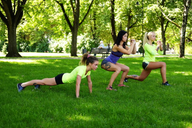 istock Females warming up on a lawn in summer park. 935534514