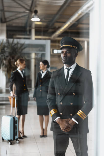 istock handsome young pilot in airport with stewardesses before flight 935535052