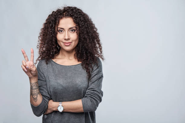 Hand counting - two fingers. Hand counting - two fingers. Smiling woman showing two fingers, V sign peace sign gesture photos stock pictures, royalty-free photos & images