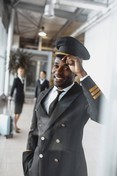 istock happy young pilot in airport looking at camera 935541714