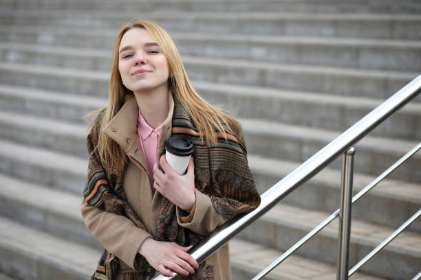 istock Cute blonde in the city drinking coffee 935542198