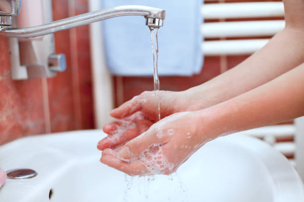 istock Hand washing under running water in bathroom 935559516