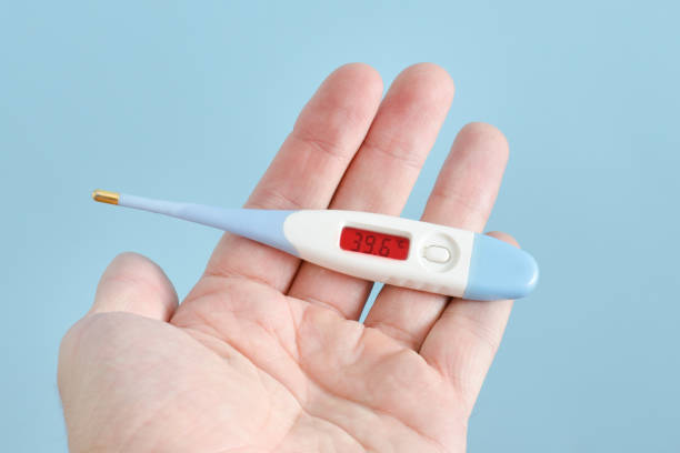 istock Electronic thermometer in a man's hand. Elevated body temperature. Close up 935559686