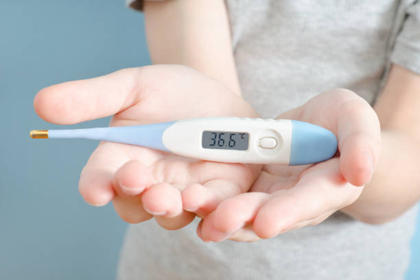 istock Electronic thermometer in a children's hands. Normal temperature. Close up 935559692