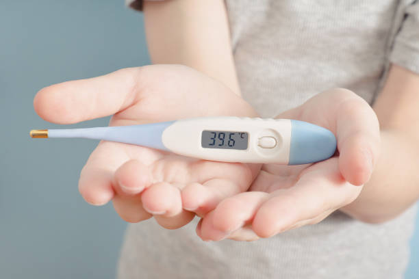 istock Electronic thermometer in a children's hands. Elevated body temperature. Close up 935559702