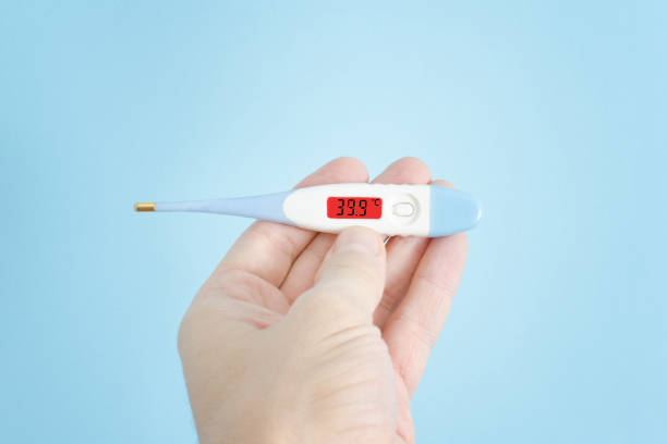 istock Electronic thermometer in a man's hand. Elevated body temperature. Close up 935559704