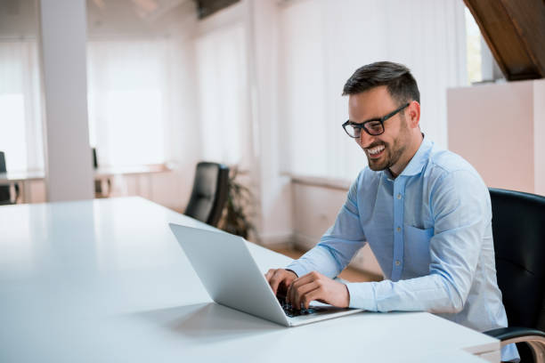 istock Happy young businessman using laptop at his office desk. 935566160