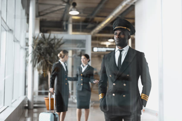 istock thoughtful young pilot in airport with stewardesses before flight 935566306