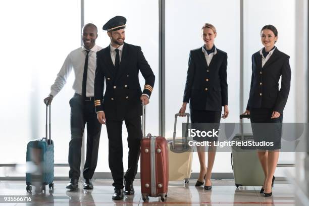 Young Aviation Personnel Team Walking By Airport Loggy With Suitcases Stock Photo - Download Image Now