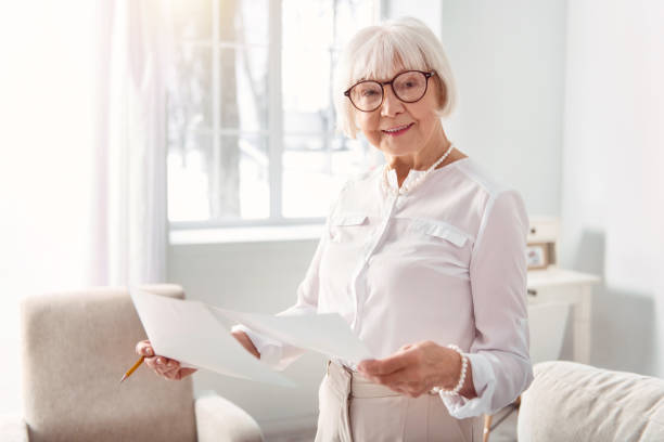istock Smiling elderly woman studying documents with research results 935571954