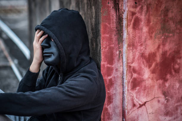 istock Mystery man with black mask in headache gesture feeling stressed 935572004