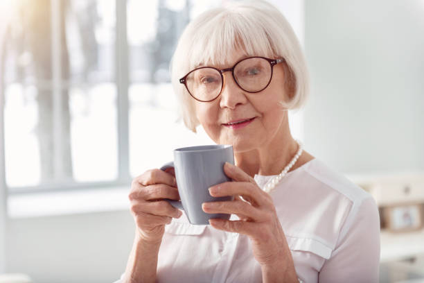 istock Close up of pretty elderly woman drinking coffee 935572020