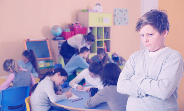 istock Unhappy schoolboy standing  at class,  children drawing 935572242