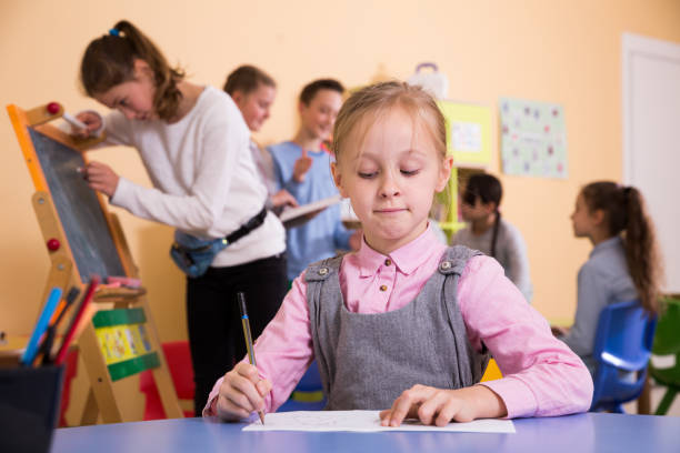 istock Schoolgirl drawing at break in school 935572372