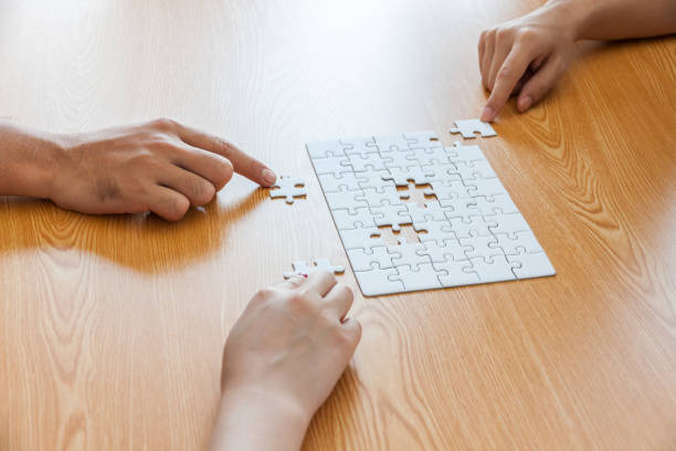 istock Business people assembling jigsaw puzzle and represent team support and help concept in office, business people assembling jigsaw puzzle and represent team support and help concept 935589318